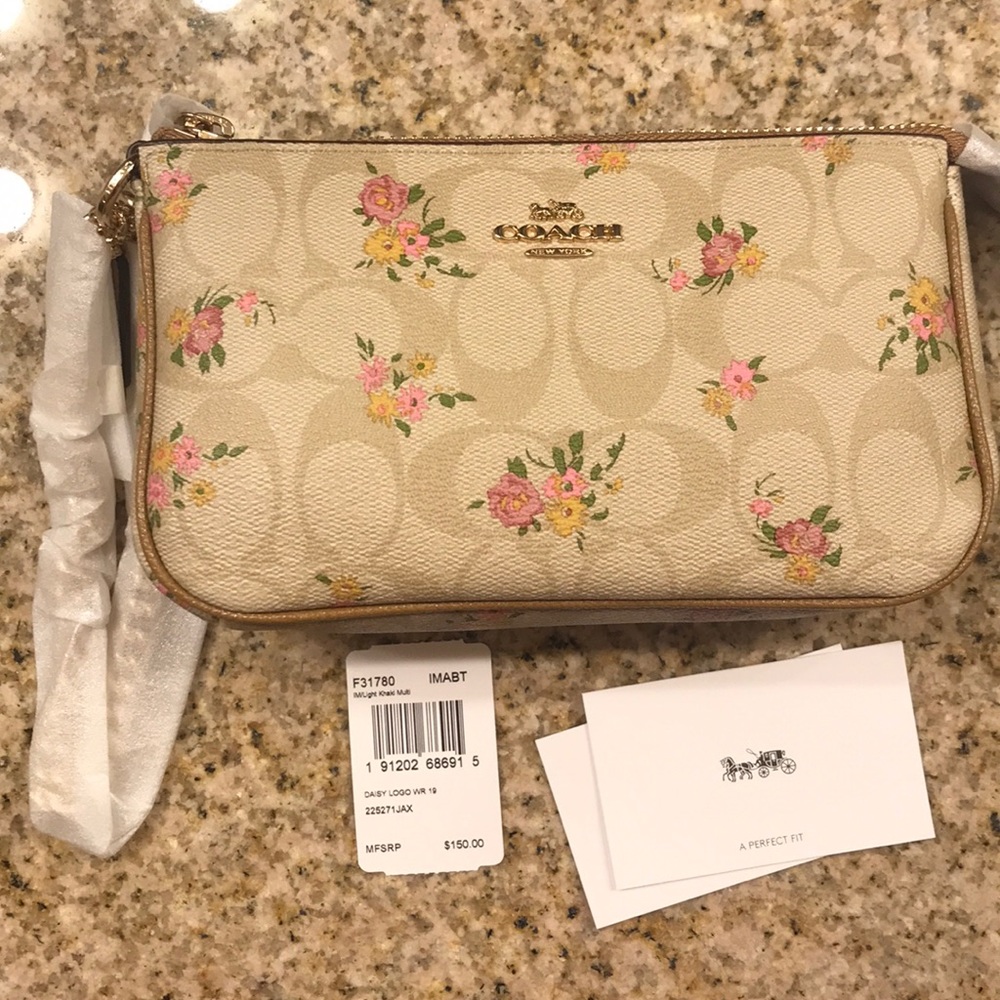 Coach wristlet with flower detail.